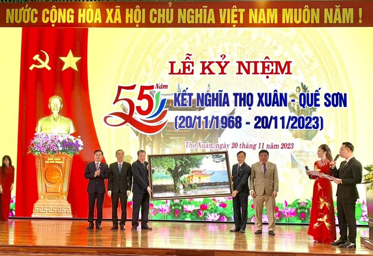 Lãnh đạo huyện Nông Sơn tặng bức tranh Dinh bà Thu bồn cho huyện Thọ Xuân. Ảnh Thái - Linh - Phương