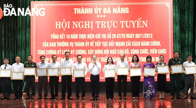 Bí thư Thành ủy Nguyễn Văn Quảng (giữa) trao Bằng khen của UBND thành phố cho các tập thể đạt thành tích xuất sắc trong 10 năm thực hiện Chỉ thị số 29-CT/TU của Thành ủy. Ảnh: N.PHÚ