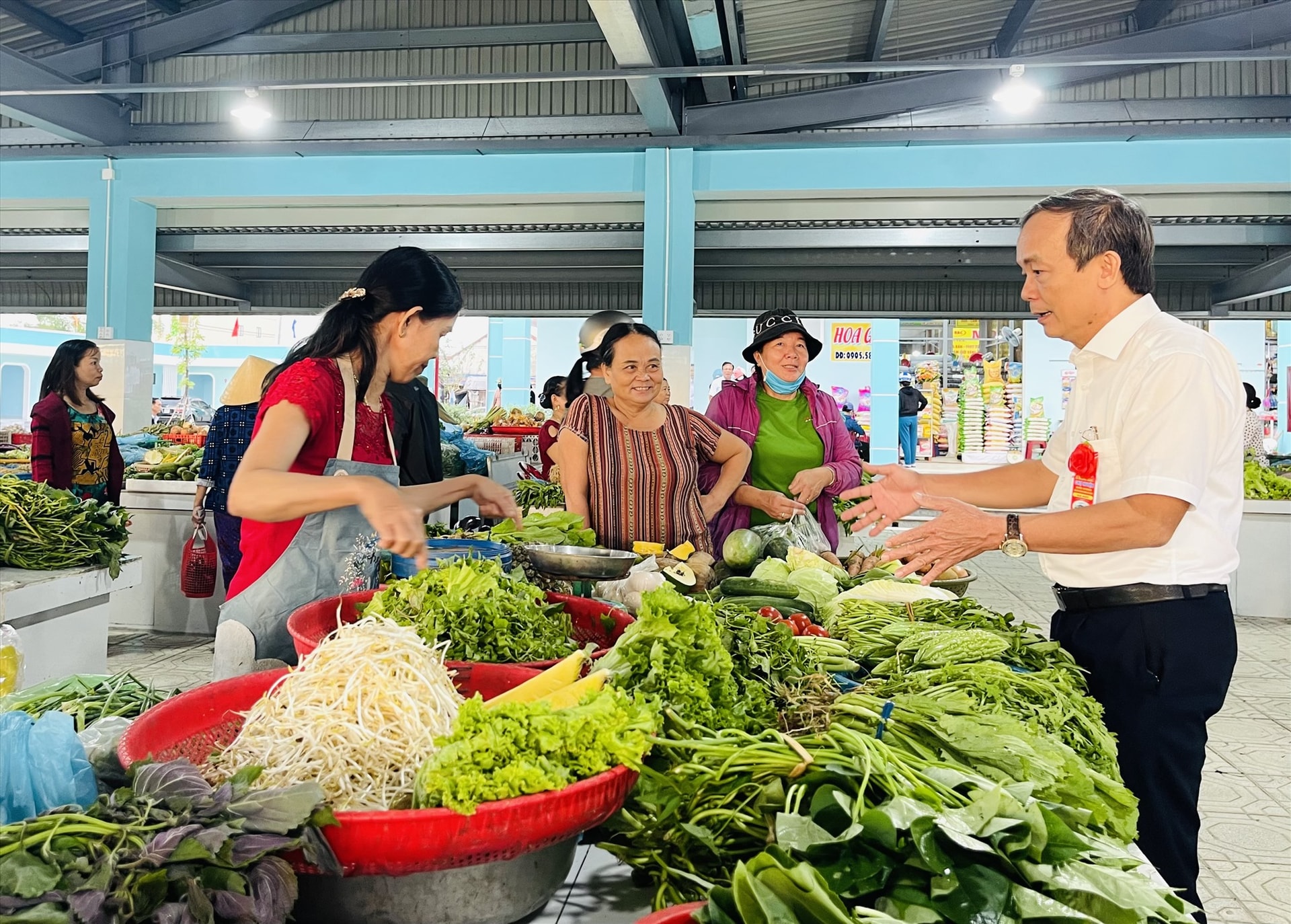 Ông Phan Xuân Cảnh – Chủ tịch UBND huyện Duy Xuyên (bên phải) trao đổi với tiểu thương tại khu chợ mới.   Ảnh: N.T