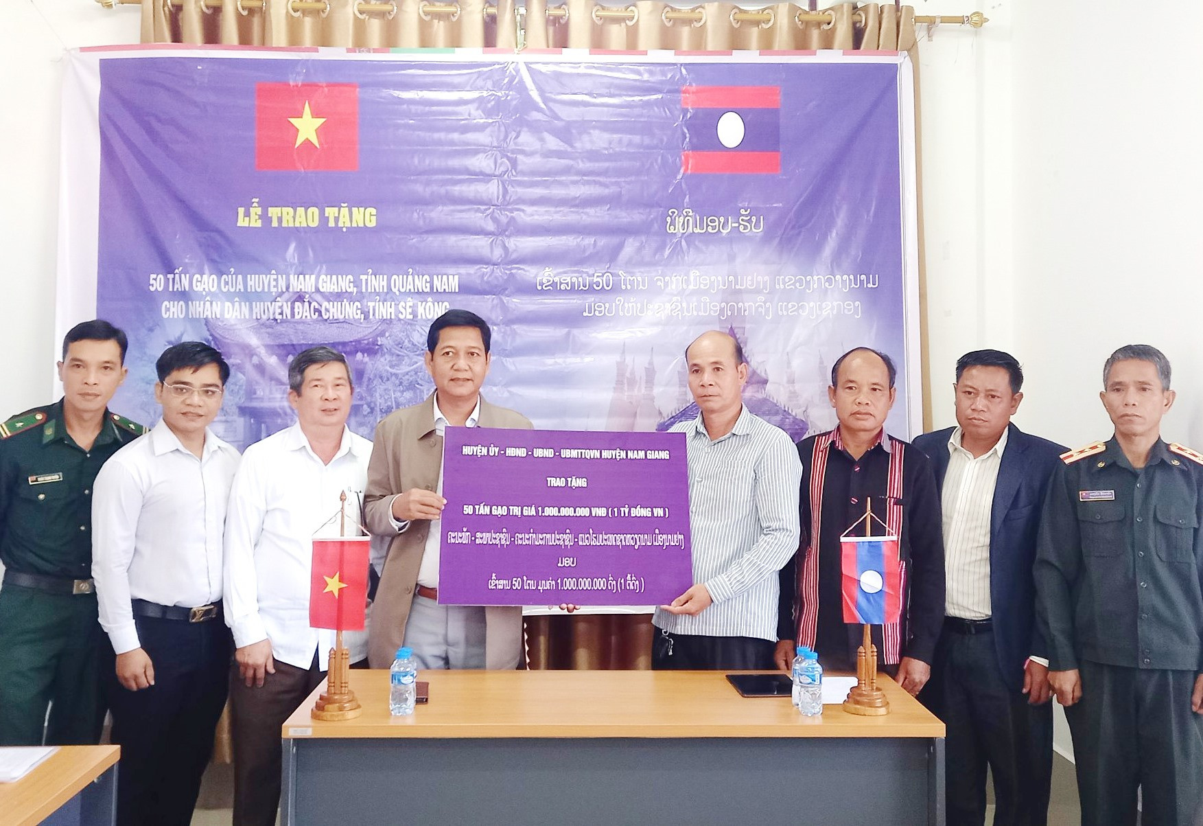 Lãnh đạo huyện Nam Giang trao bảng tượng trưng hỗ trợ huyện Đắc Chưng 50 tấn gạo. Ảnh: Đ.N