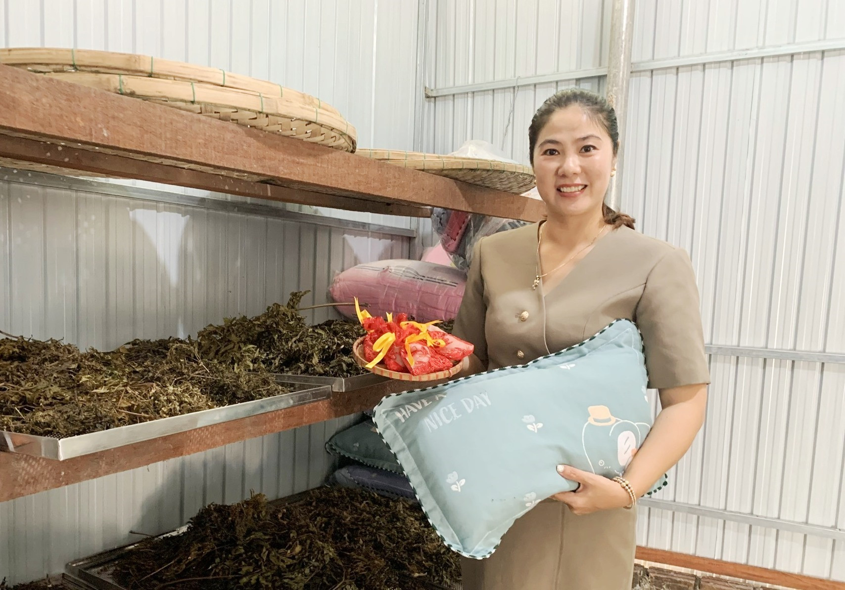 Bà Trần Thị Đoan Quỳnh với sản phẩm gối đinh lăng và túi bột quế, đinh lăng. ẢNH TÚ VÂN