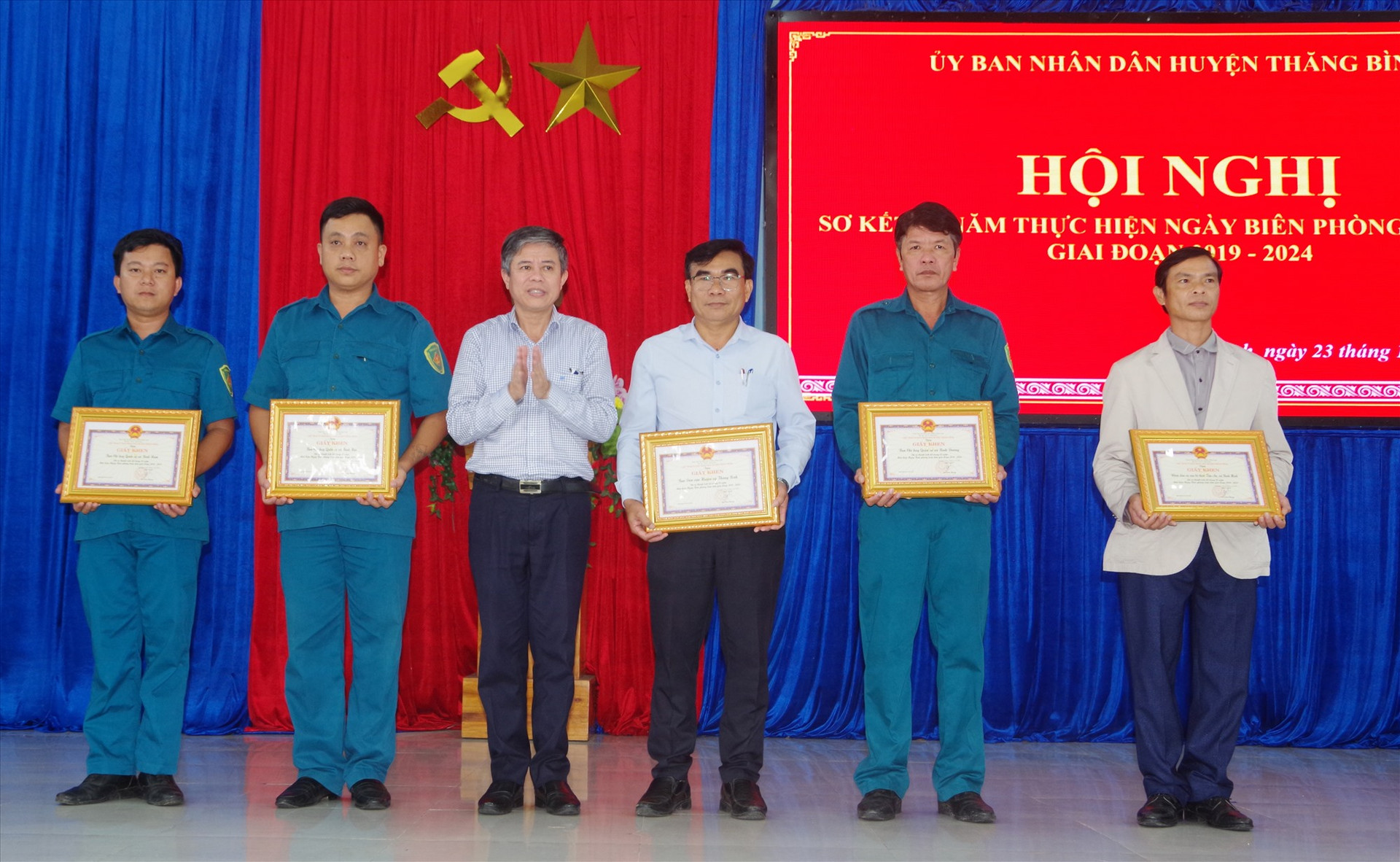 Ông Võ Văn Hùng - Chủ tịch UBND huyện tặng giấy khen các tập thể có thành tích xuất sắc trong thực hiện ngày Biên phòng toàn dân. Ảnh: HỒNG ANH