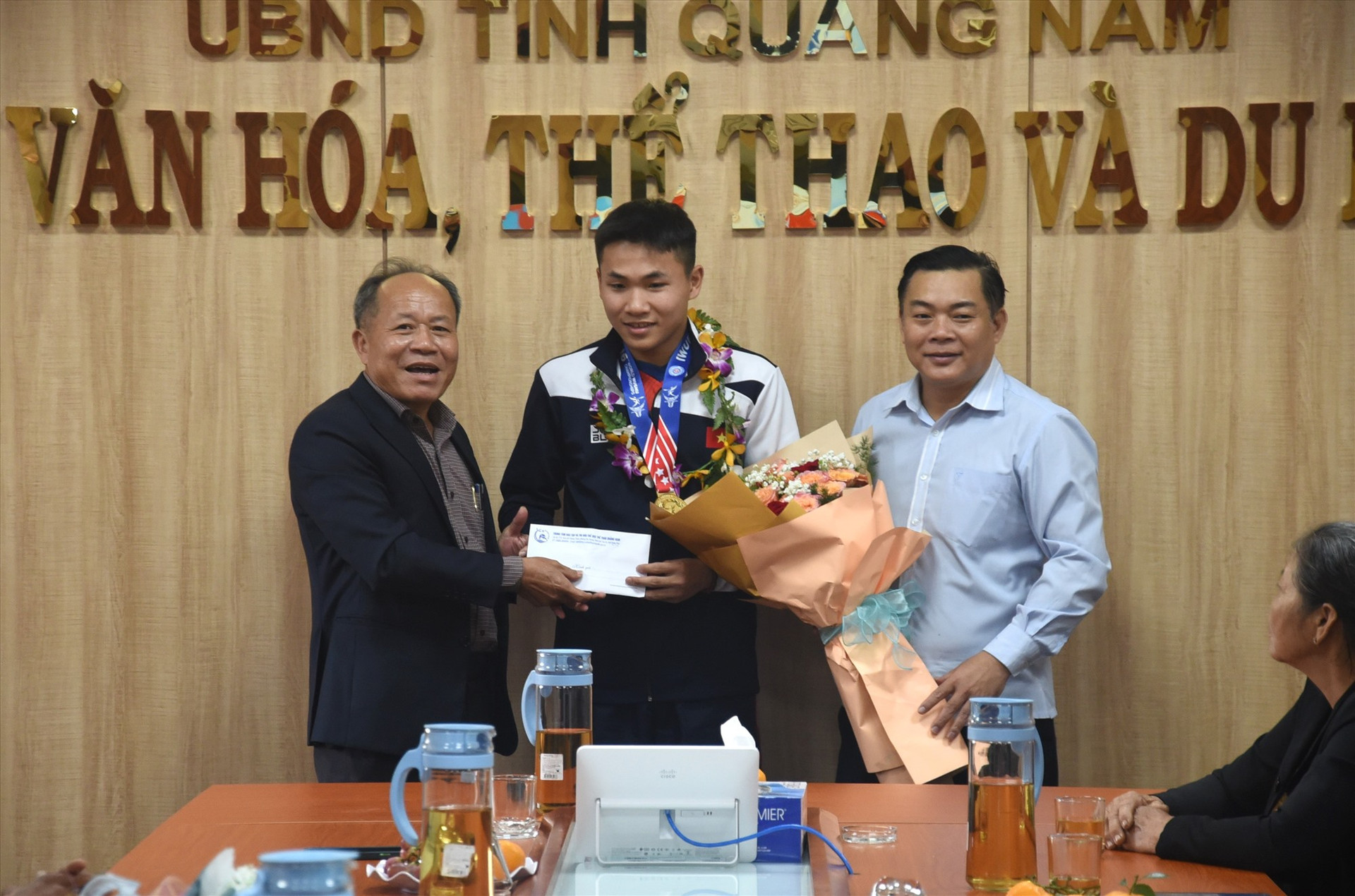 Lãnh đạo Trung tâm Đào tạo thi đấu TD-TT Quảng Nam “thưởng nóng” cho Huỳnh Đỗ Đạt. Ảnh: T.V