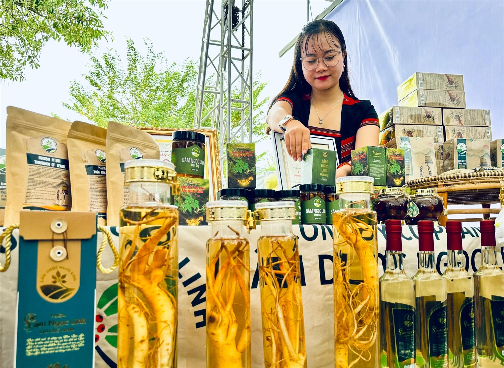 Gian hàng bày bán các sản phẩm chế biến từ sâm Ngọc Linh và dược liệu vùng núi Nam Trà My. Ảnh: ALĂNG NGƯỚC