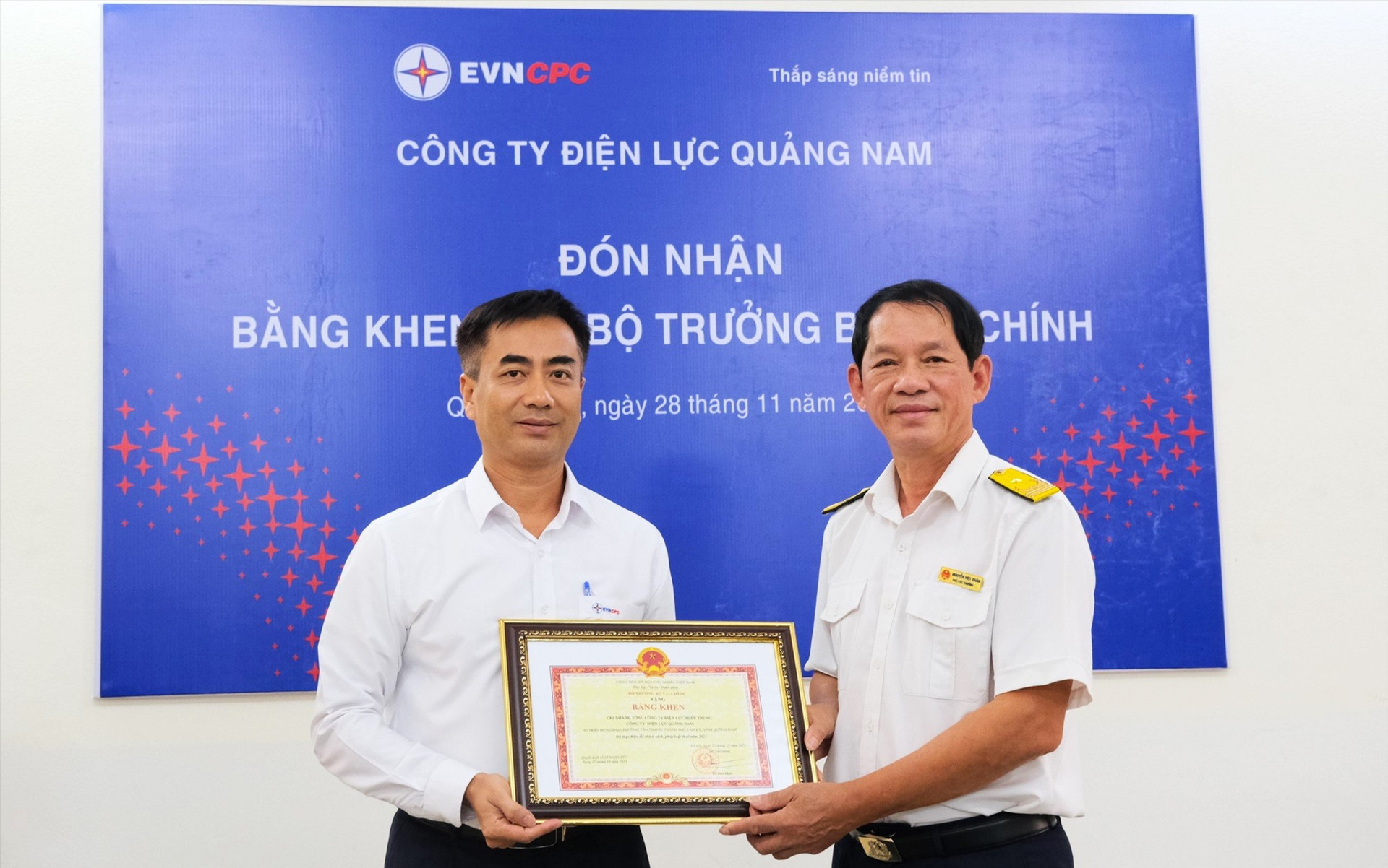 Ông Phan Văn Tuấn – Phó Giám đốc PC Quảng Nam (bên trái) nhận Bằng khen của Bộ trưởng Bộ Tài chính, được ông Nguyễn Việt Xuân – Phó Cục trưởng Cục Thuế tỉnh Quảng Nam trao.