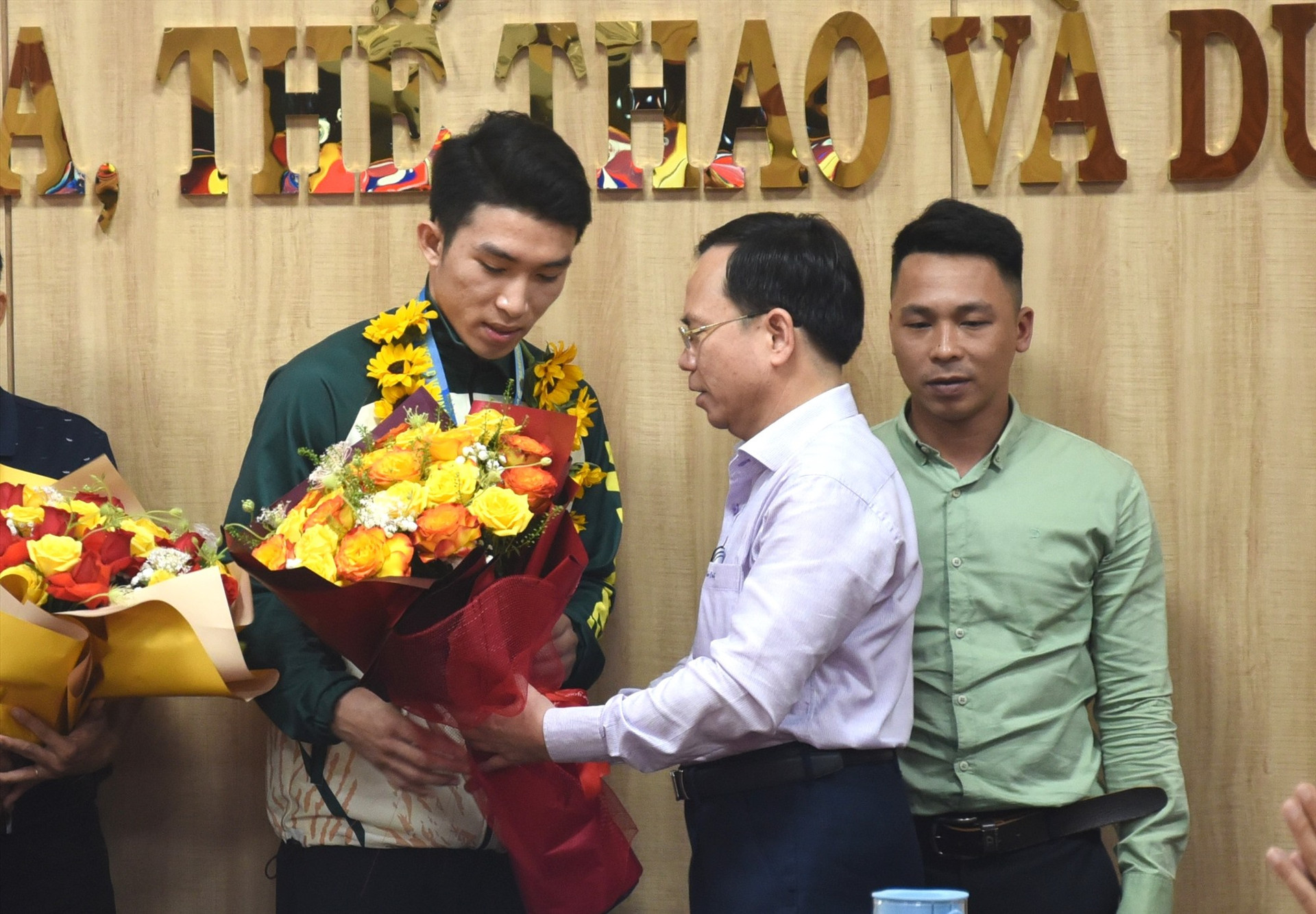 Giám đốc Sở VH-TT&DL Nguyễn Thanh Hồng tặng hoa chúc mừng thành tích xuất sắc của Bùi Xuân Nhật. Ảnh: T.V