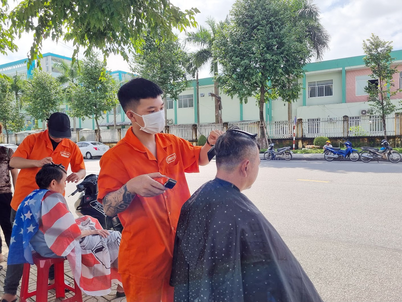 Nhân viên tiệm Mỹ Barber Shop hớt tóc miễn phí cho bệnh nhân ở góc đường Nguyễn Du – Nguyễn Chí Thanh. Ảnh: C.N