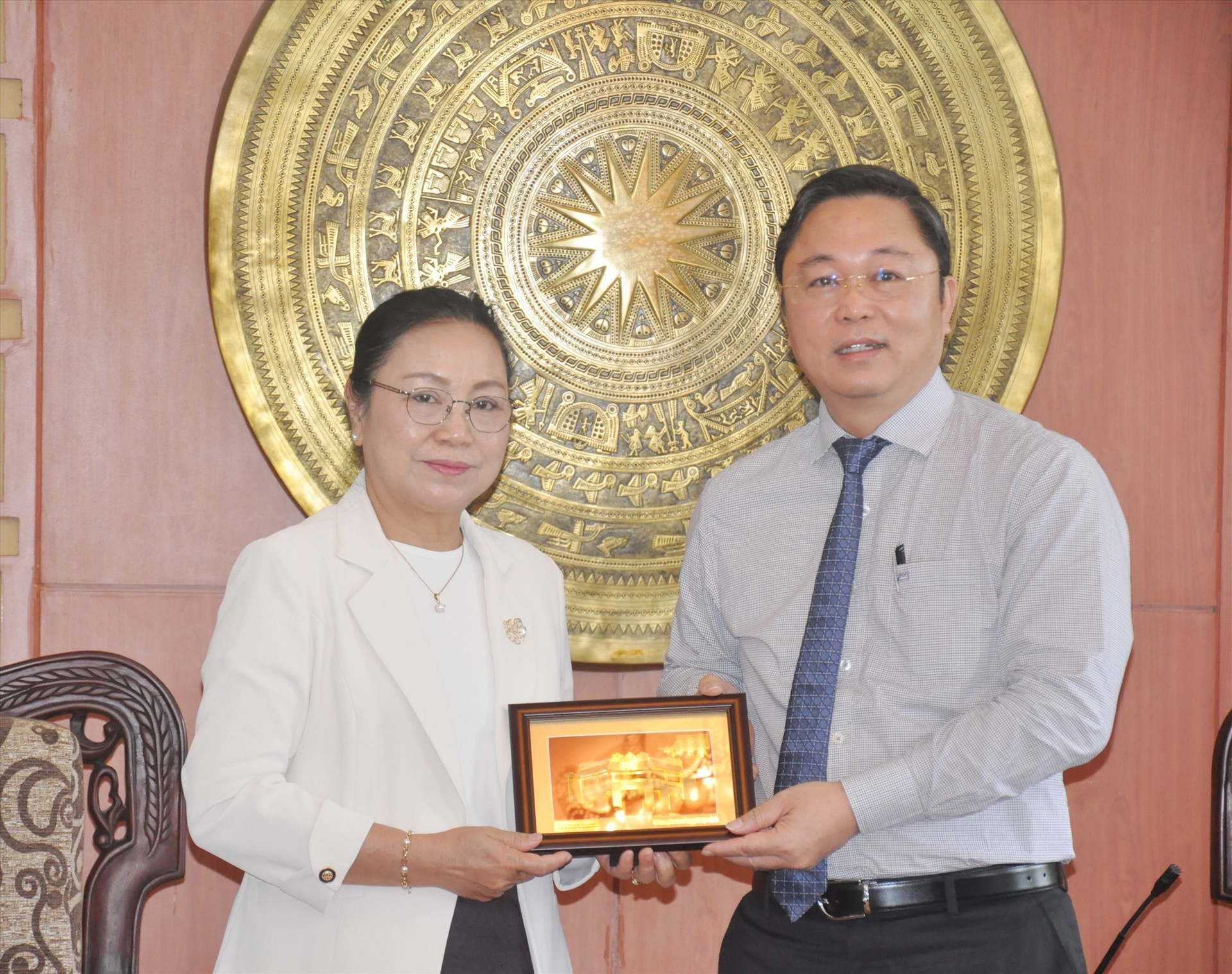 Chủ tịch UBND tỉnh Lê Trí Thanh tặng quà lưu niệm cho bà Khăm-pha Ân-thạ-văn đại sứ đặc mệnh toàn quyền Lào tại Việt Nam. Ảnh: N.Đ