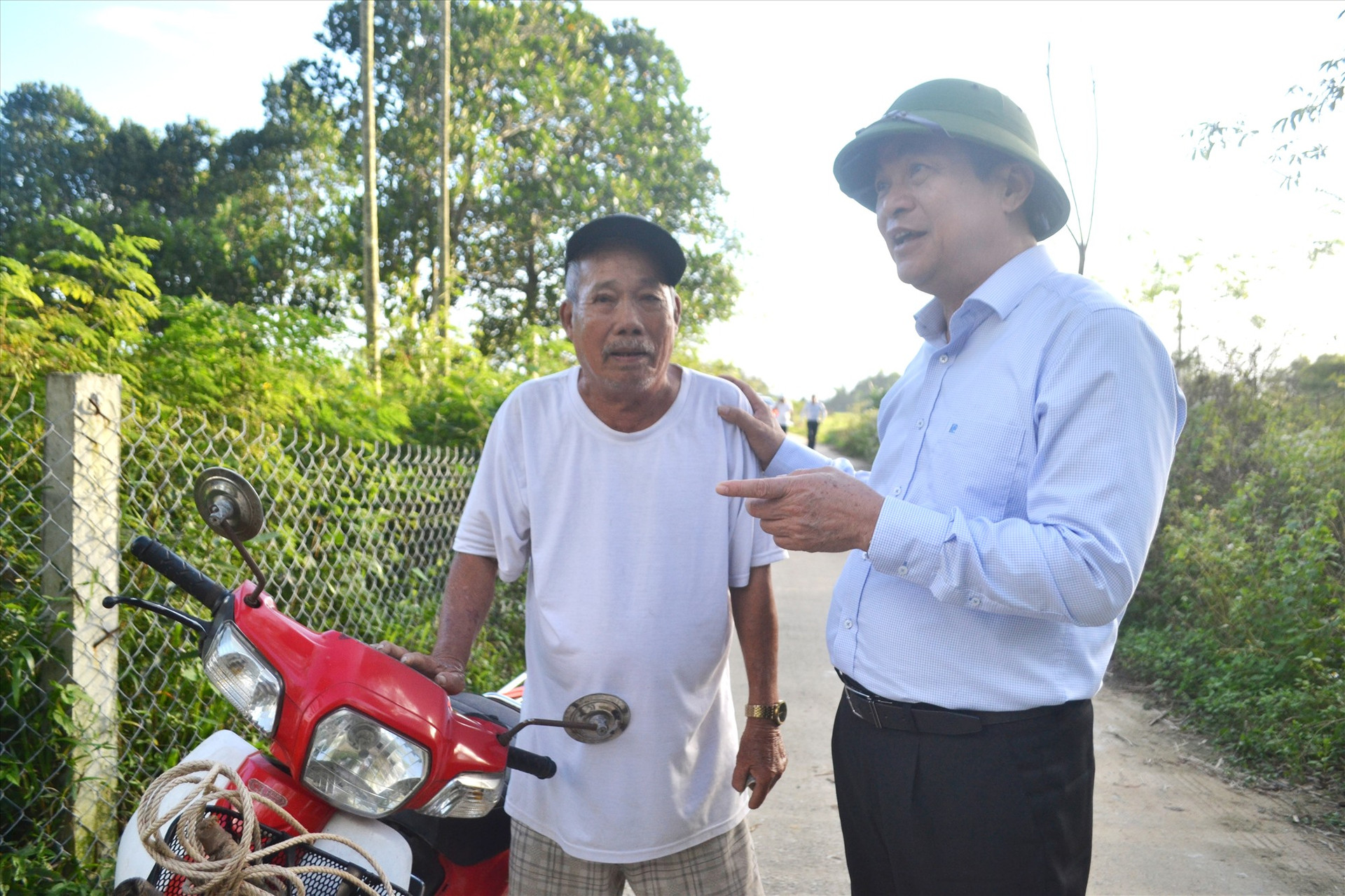 Đồng chí Phan Việt Cường nói chuyện với người dân thôn Xuân Diệm (xã Điện Tiến), nơi có cầu Quảng Đà bắc qua. Ảnh: C.T