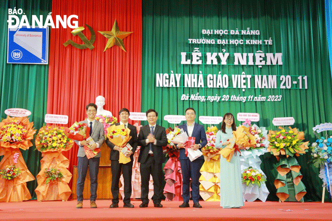 Trường Đại học Kinh tế vinh danh 4 tân tiến sĩ học tập quay trở lại công tác. Ảnh: NGỌC HÀ
