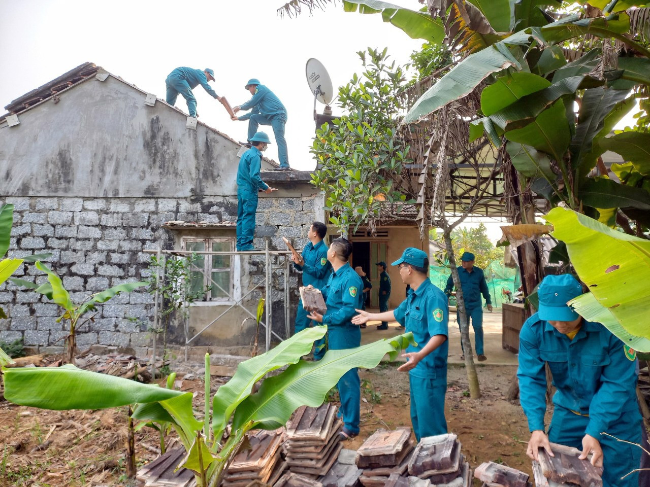 Lực lượng dân quân huyện Quế Sơn tham gia tháo dỡ căn nhà bị hư hại của bà Lâm Thị Lượm sau mưa lũ. Ảnh: KHÁNH NGUYÊN
