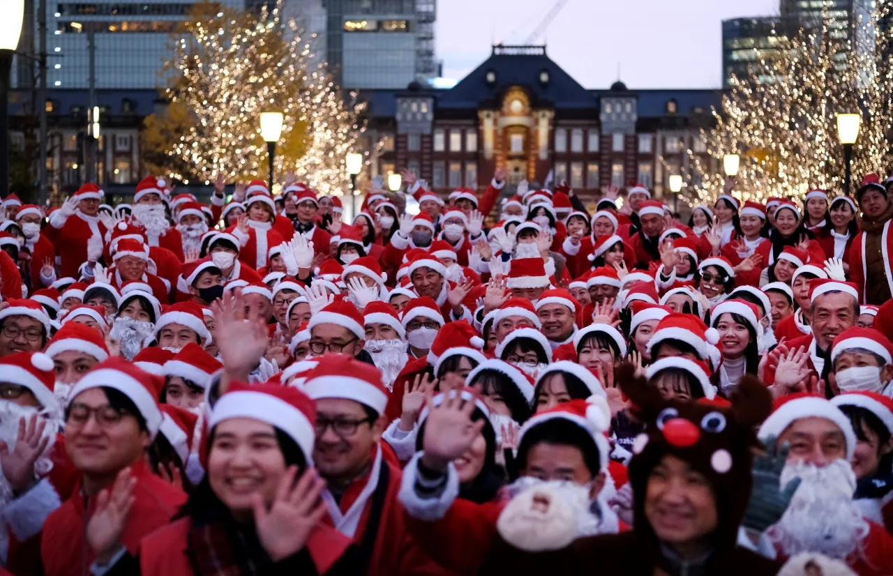 Workers dressed as Santa Claus pose for photos before their parade at Marunouchi business district located near Tokyo Station, rear, in Tokyo, Japan, on Dec. 22, 2023. (KAZUHIRO NOGI/AFP via Getty Images)