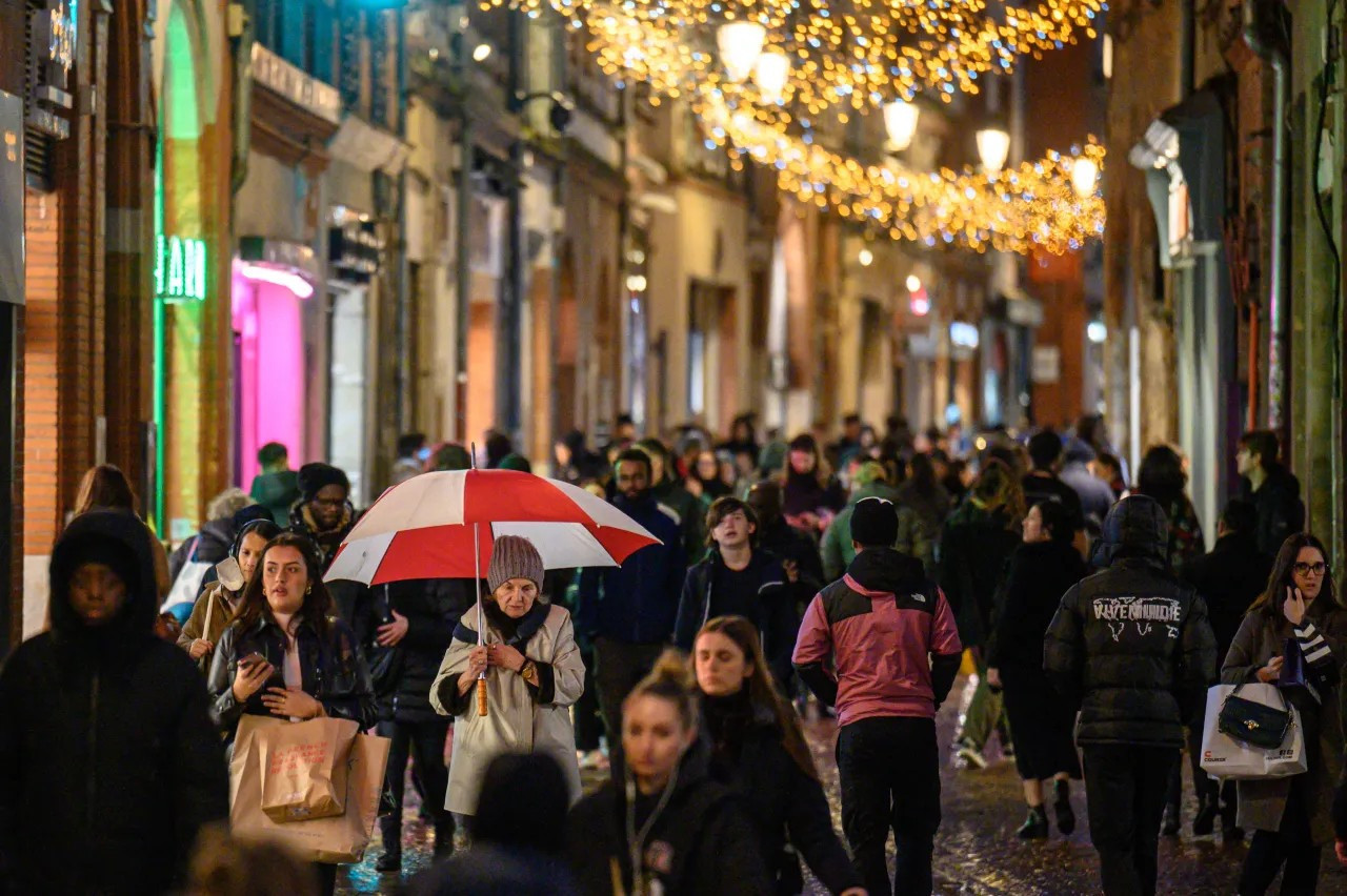 Shoppers and commuters make their way along a main street a few days before Christmas in Toulouse, France, on Dec. 21, 2023. (ED JONES/AFP via Getty Images)