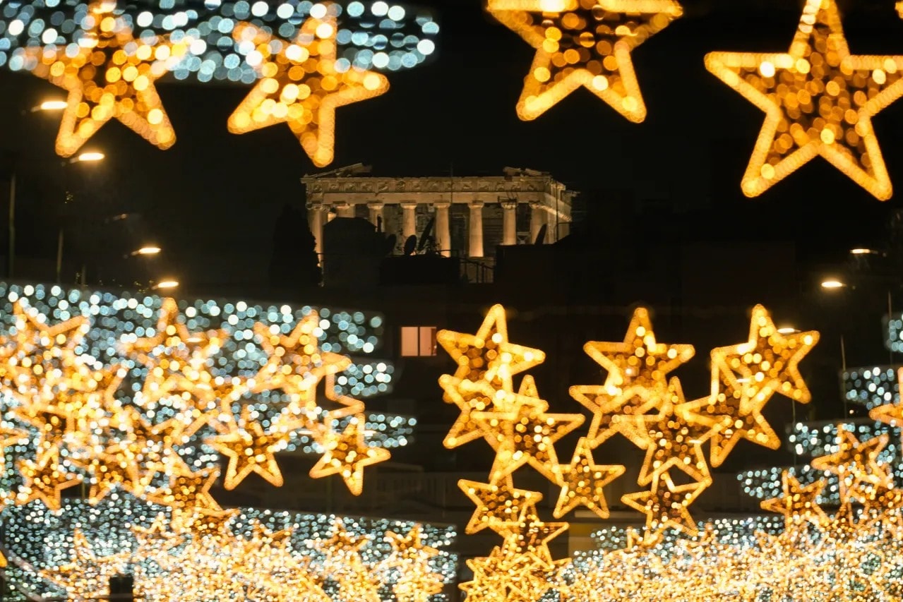 The spotlit ancient Parthenon temple on the Acropolis appears behind strings of Christmas lights in Athens, Greece, on Dec. 20, 2023. (AP Photo/Thanassis Stavrakis)