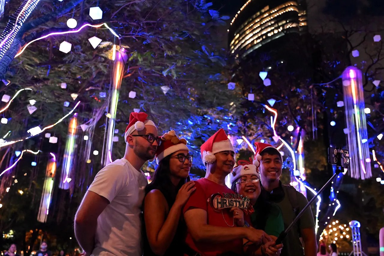 People take a selfie during a Christmas light show ahead of festivities at a park in Makati, Metro Manila, Philippines, on Dec. 22, 2023. (JAM STA ROSA/AFP via Getty Images)