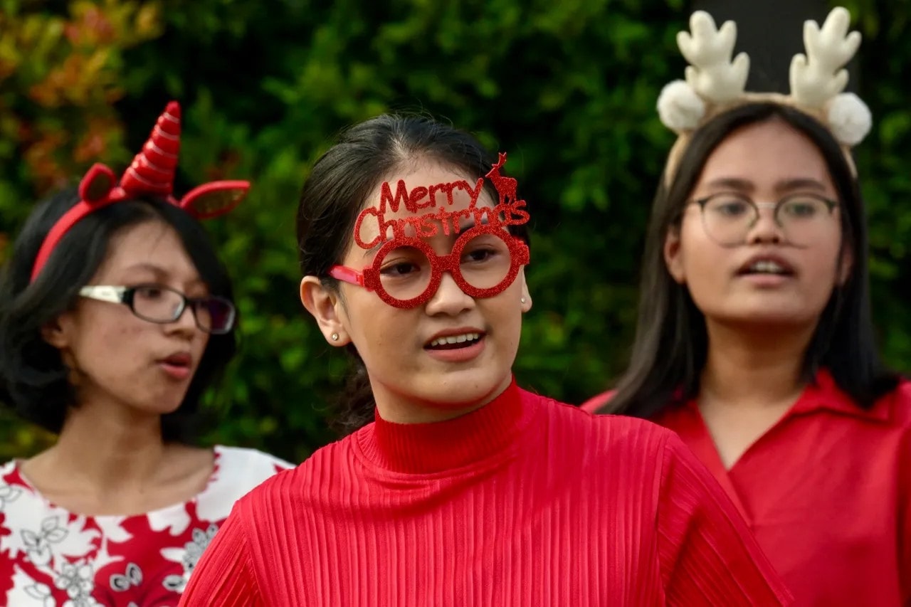 People sing Christmas carols on a sidewalk in Jakarta, Indonesia, on Dec. 22, 2023. (BAY ISMOYO/AFP via Getty Images)