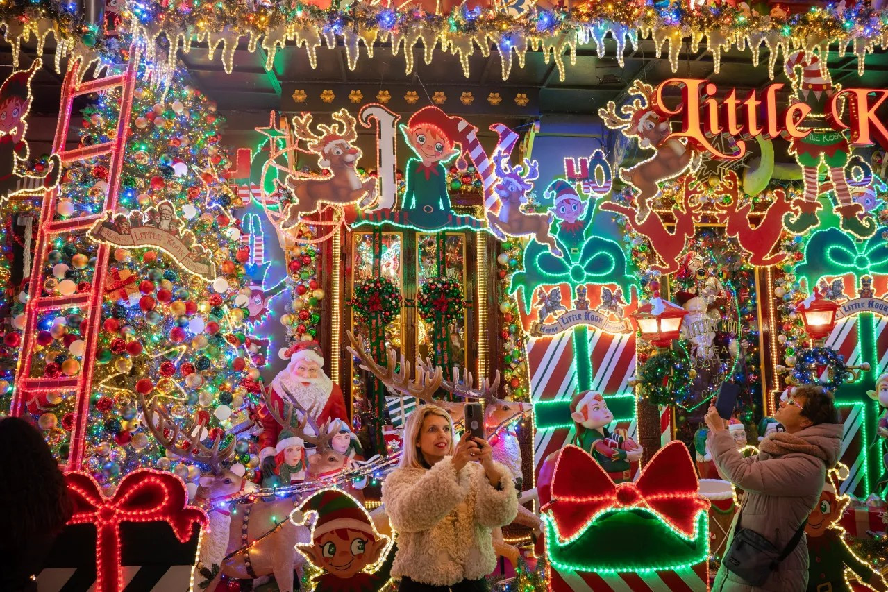 esidents take pictures of a cafe decorated for Christmas in Athens, Greece, on Dec. 22, 2023. (ANGELOS TZORTZINIS/AFP via Getty Images)