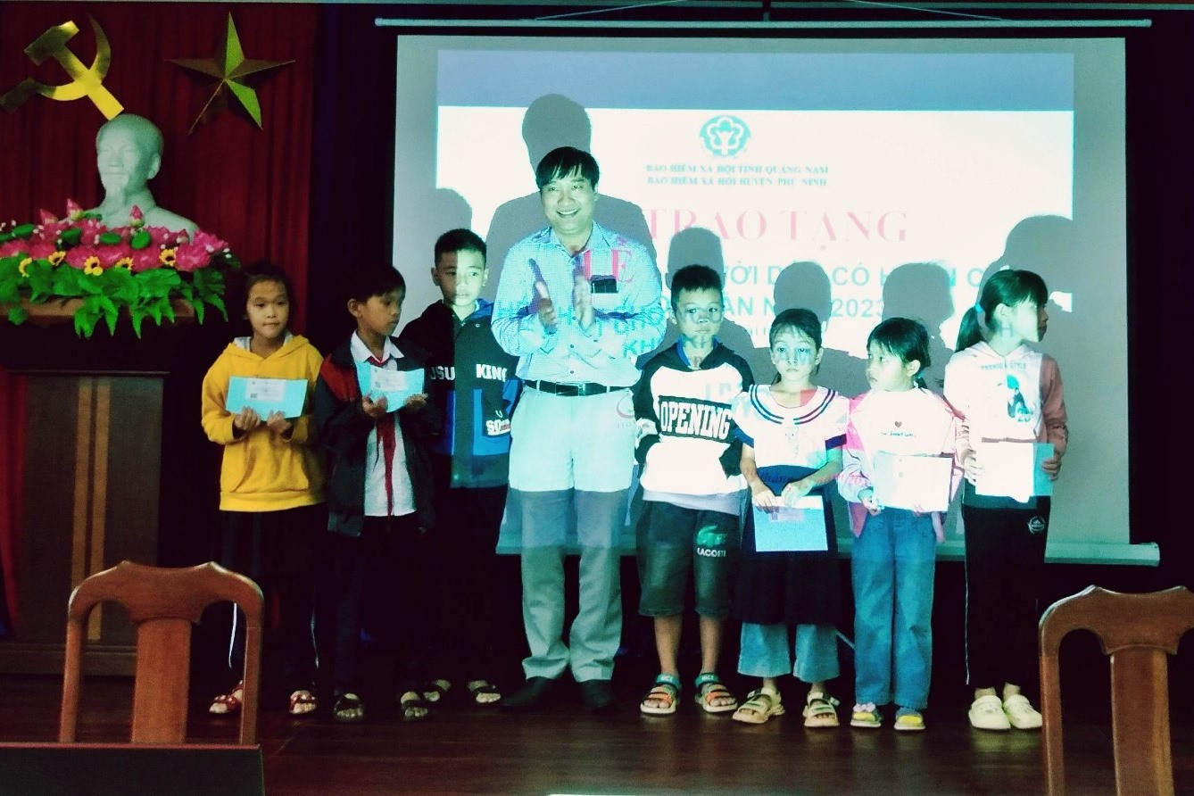 Lãnh đạo BHXH huyện Phú Ninh tặng thẻ BHYT cho học sinh có hoàn cảnh khó khăn trên địa bàn huyện. Ảnh: H.Đ