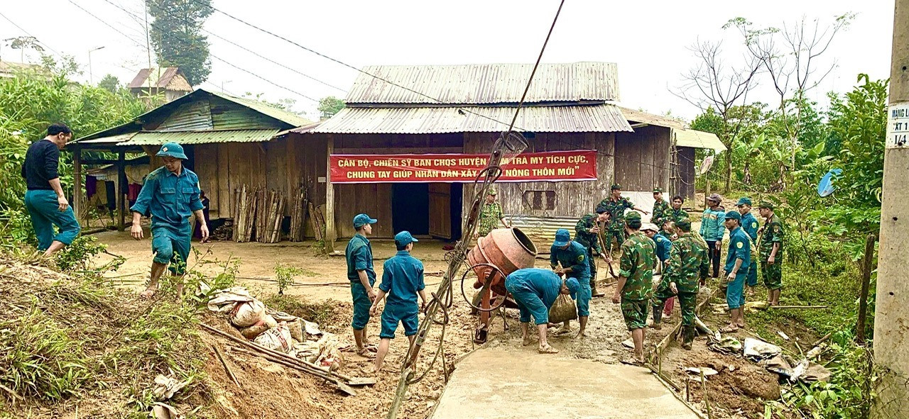 Cán bộ chiến sĩ ban chỉ huy quân sự huyện giúp nhân dân làm đường bê tông tại làng Măng Lin xã Trà Vân.