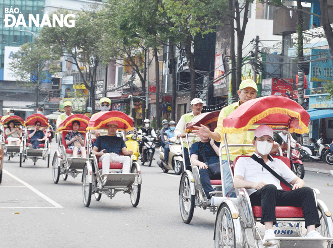 Du khách tham quan thành phố bằng xích lô.  Ảnh: THU HÀ