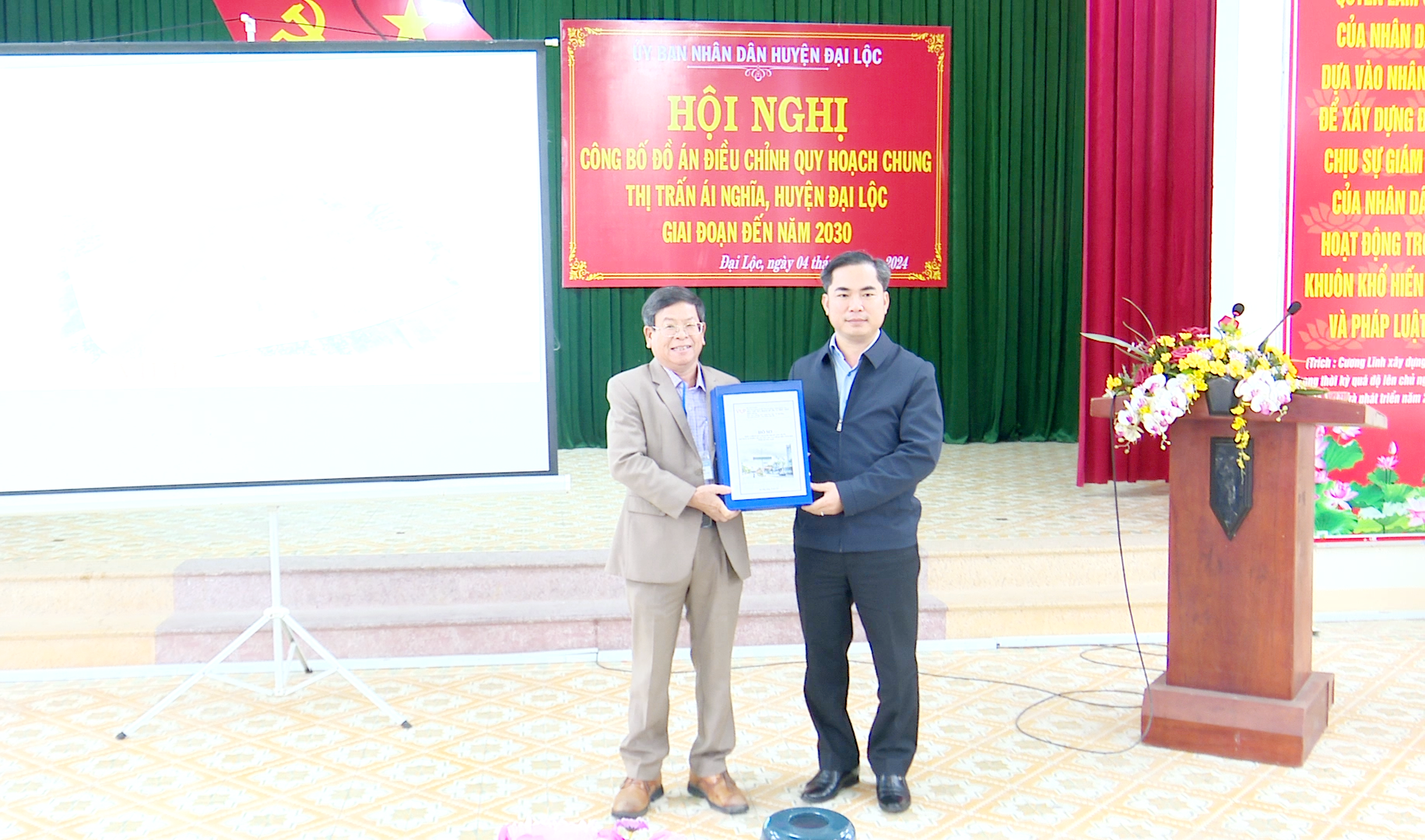 Chủ tịch UBND huyện Đại Lộc - Lê Văn Quang trao quyết định quy hoạch chung thị trấn Ái Nghĩa cho lãnh đạo thị trấn.