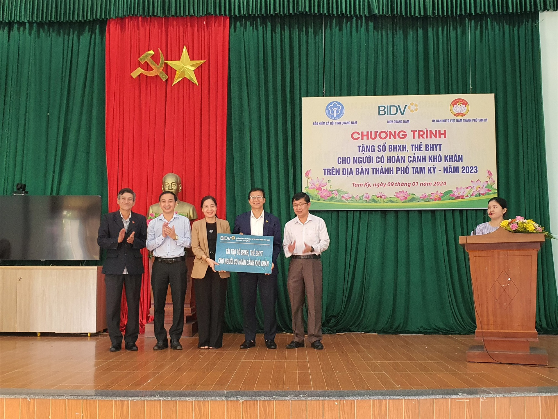 Đơn vị tài trợ trao bảng tượng trưng hỗ trợ sổ BHXH và thẻ BHYT cho người dân Quảng Nam.