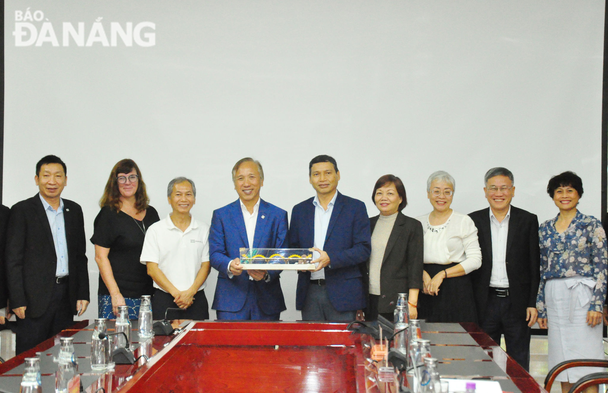 Phó Chủ tịch Thường trực UBND thành phố Hồ Kỳ Minh (thứ 5 từ phải sang) tặng quà lưu niệm cho lãnh đạo Công ty Marvell. Ảnh: THÀNH LÂN