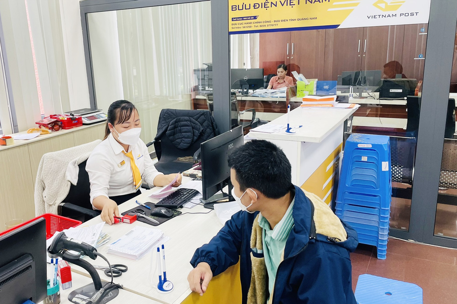 Nhân viên bưu điện thay cán bộ, công chức các sở, ban, ngành tiếp nhận hồ sơ TTHC tại Trung tâm Phục vụ HCC tỉnh. Ảnh: PV