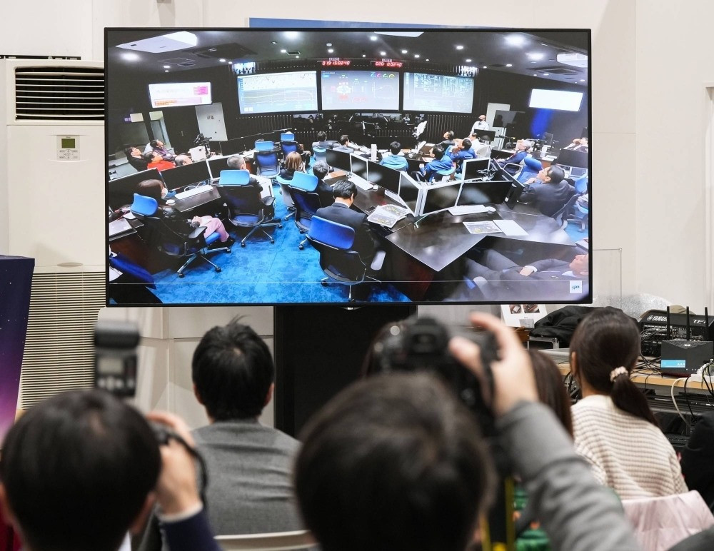 Một màn hình chiếu cảnh các quan chức JAXA trong phòng điều khiển sứ mệnh tại khuôn viên của cơ quan vũ trụ ở Sagamihara, tỉnh Kanagawa, vào thứ Bảy. | KYODO