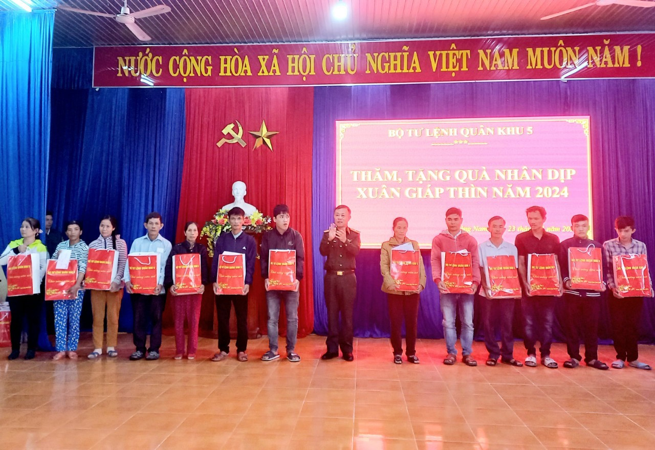 Thiếu tướng Nguyễn Quốc Hương - Phó Tư lệnh Quân khu 5 tặng quà người dân xã Quế Thuận. Ảnh: DUY THÁI