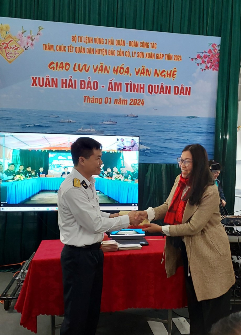 Đồng chí Huỳnh Thị Hồng Kiều - Bí thư Đảng ủy xã Tam Hải (Núi Thành) trao quà cho đại diện các lực lượng quân dân đảo Cồn Cỏ.