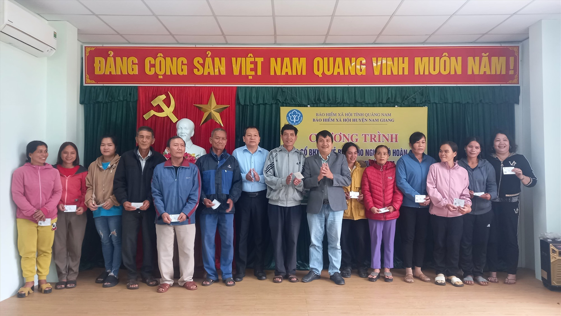 Lãnh đạo BHXH huyện Nam Giang trao thẻ BHYT cho người dân khó khăn.