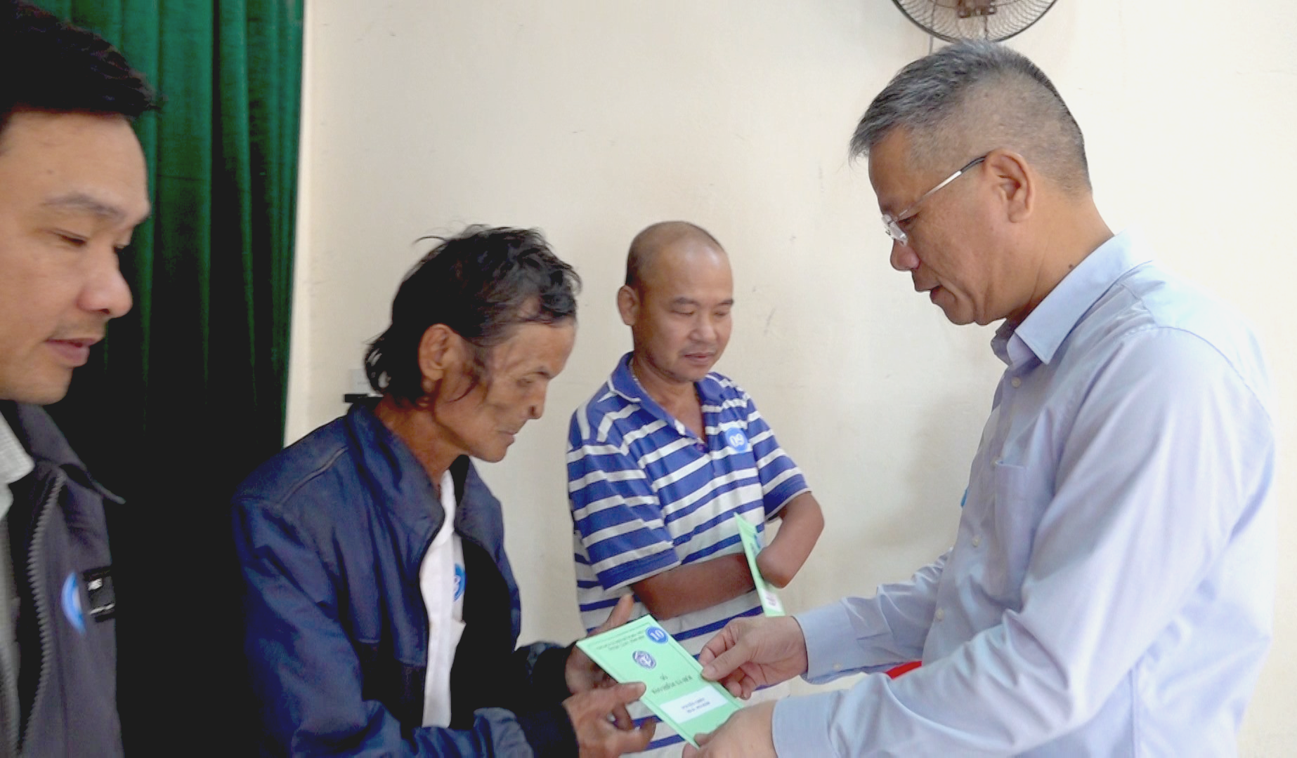 Phó Tổng giám đốc BHXH Việt Nam Trần Đình Liệu trao tặng sổ BHXH cho người dân có hoàn cảnh khó khăn của huyện Núi Thành. Ảnh: Đ.Y