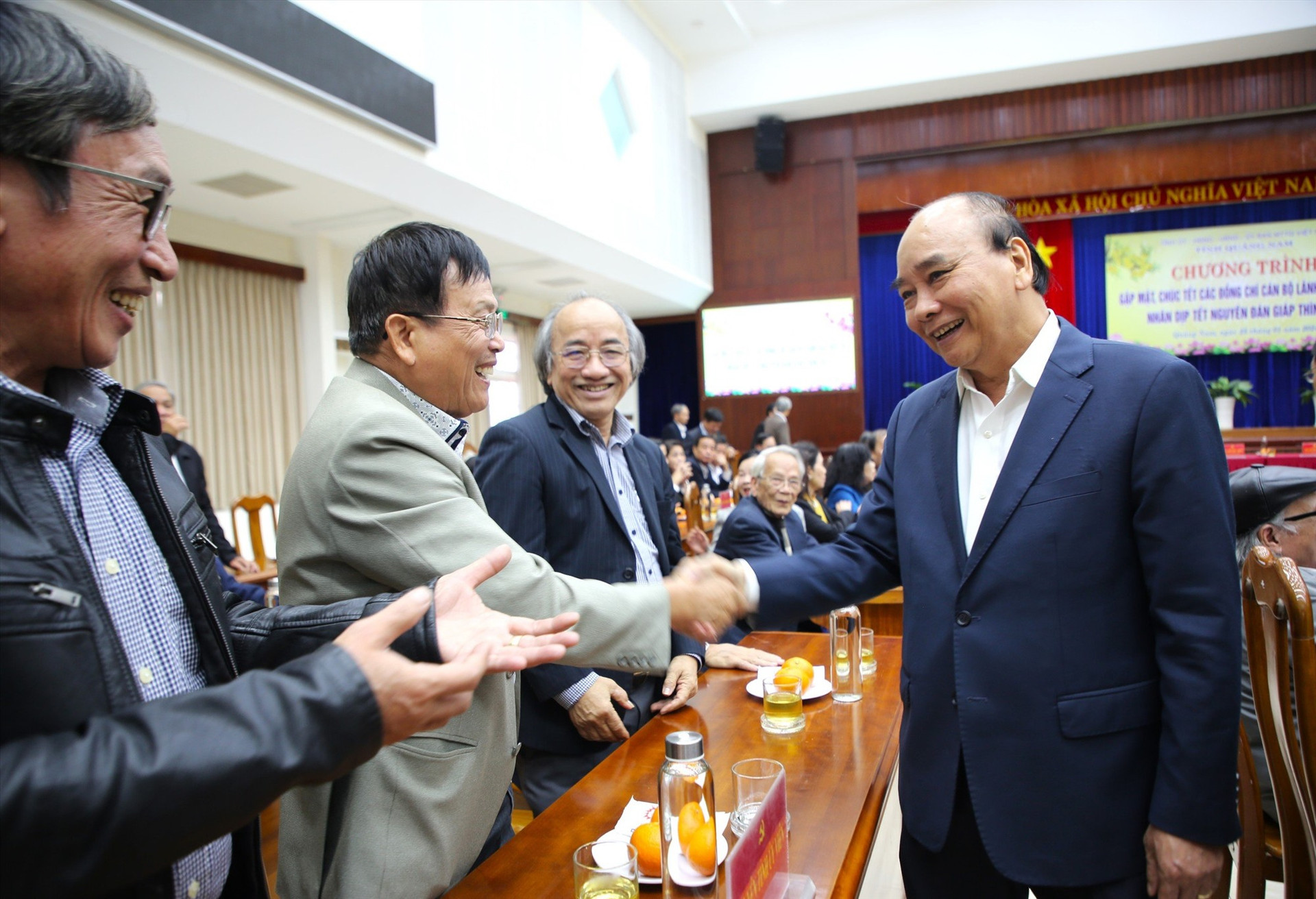 Nguyên Chủ tịch nước Nguyễn Xuân Phúc thăm hỏi cán bộ tỉnh nghỉ hưu tại chương trình gặp mặt. Ảnh: A.N