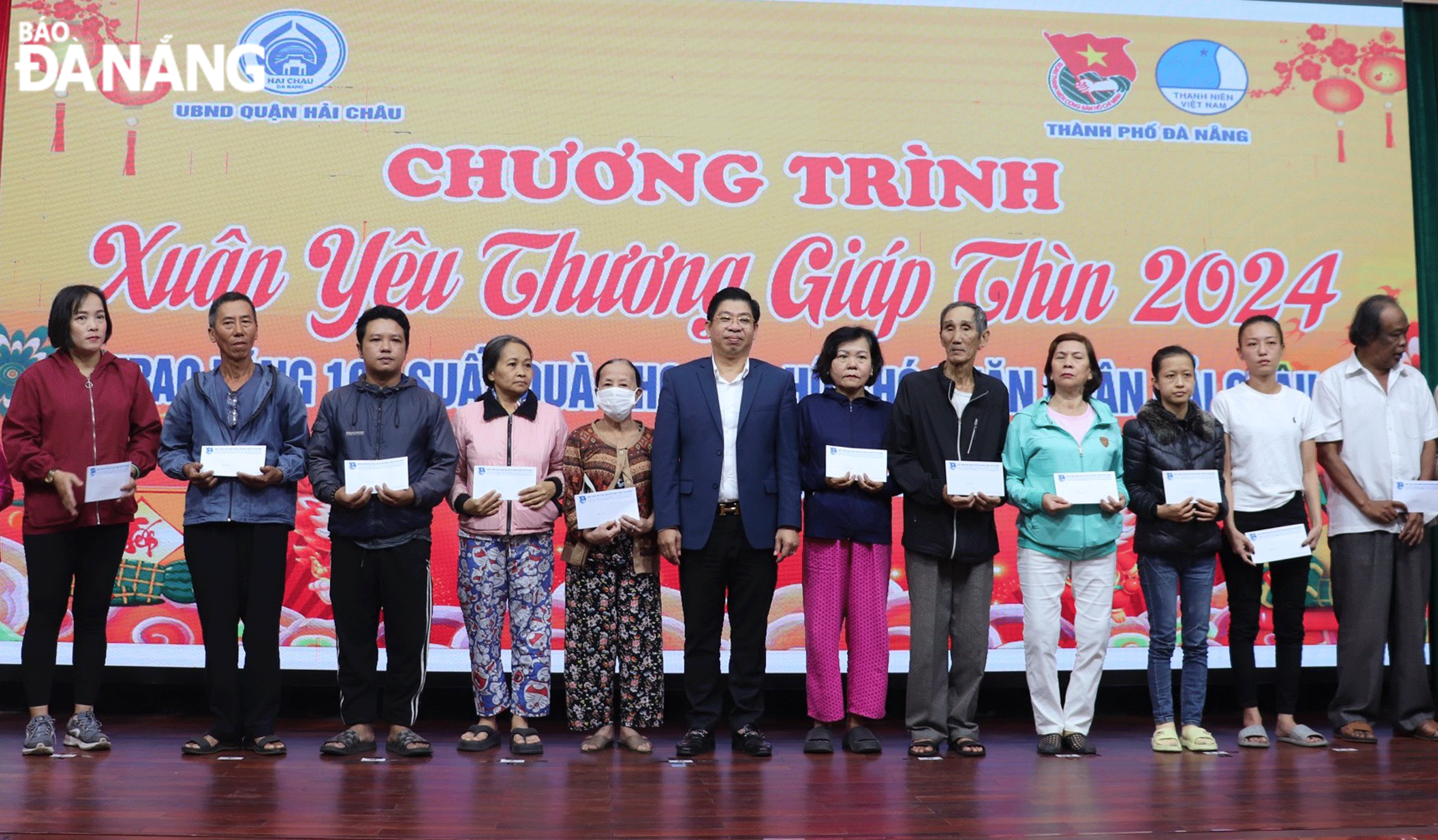 Phó Chủ tịch Thường trực UBND quận Hải Châu Trương Thanh Dũng (thứ sáu, bên trái sang) trao quà cho các hộ gia đình có hoàn cảnh khó khăn trong chương trình “Xuân yêu thương Giáp Thìn 2024” tổ chức vào ngày 20-1. Ảnh: VĂN HOÀNG