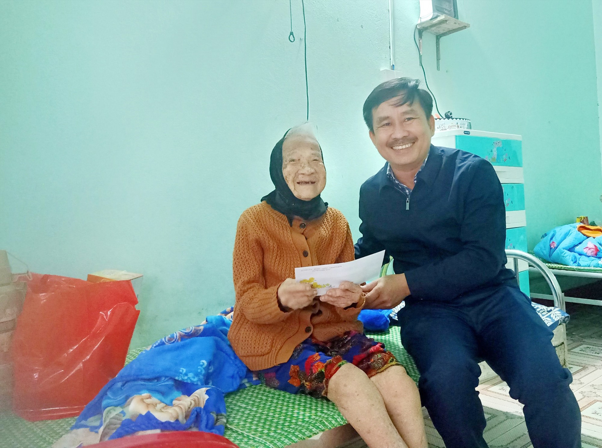 Ông Hoàng Văn Hùng - Phó Chủ tịch UBND huyện tặng quà tết cho người già tại Trung tâm Dưỡng lão Hiệp Đức. Ảnh: CTV