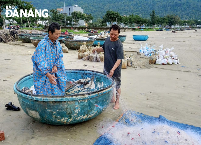 Ngư dân làng cá Nam Thọ xâu lưới chuẩn bị cho buổi chiều đi lộng. Ảnh: THÁI MỸ