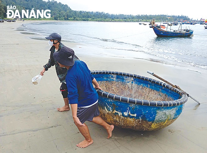 Ngư dân kéo thúng chai lên bờ nghỉ ngơi sau một đêm trên sóng vất vả. Ảnh: THÁI MỸ