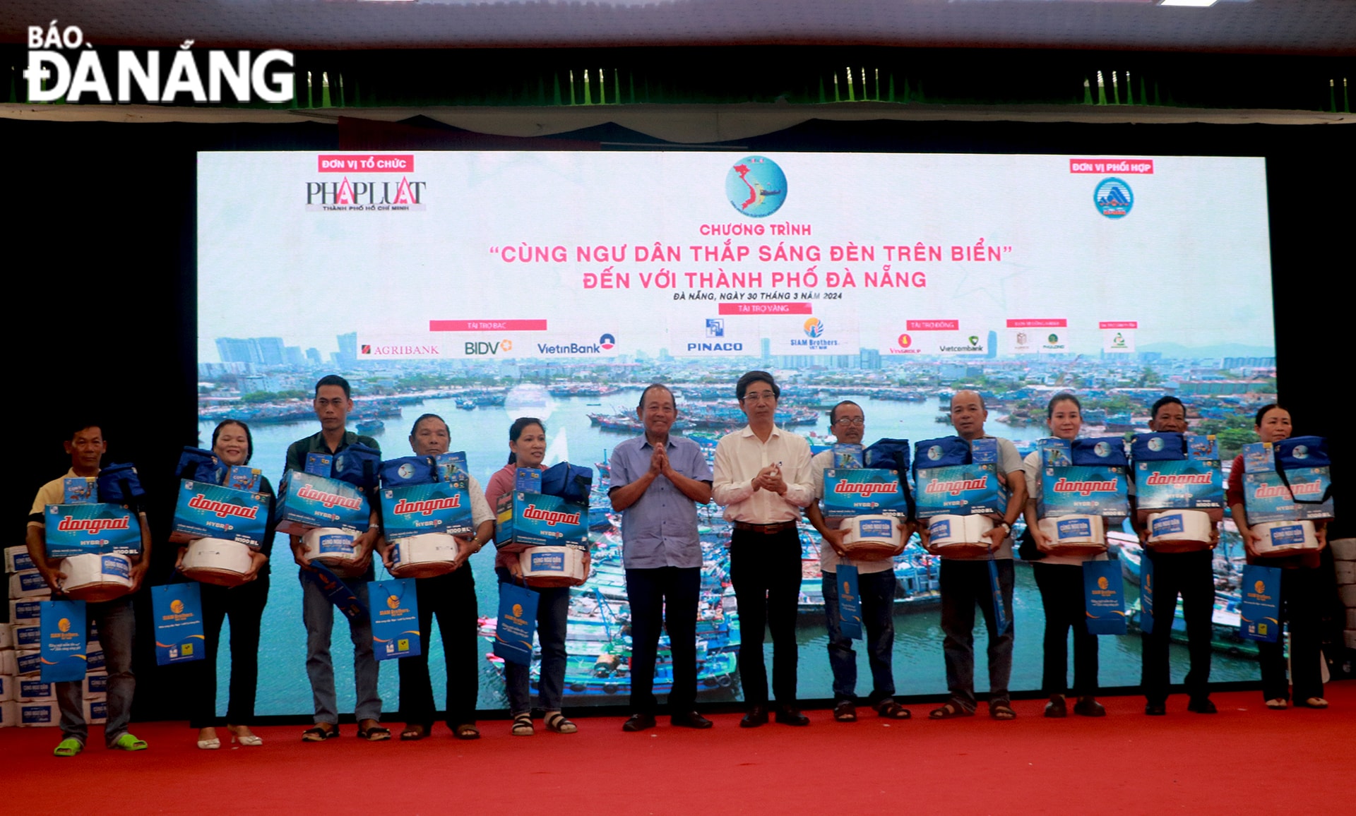 Nguyên Ủy viên Bộ Chính trị, nguyên Phó Thủ tướng Thường trực Chính phủ Trương Hòa Bình (thứ 6, bên trái sang) và Phó Chủ tịch UBND thành phố Trần Chí Cường (thứ 7, bên trái sang) trao quà cho ngư dân tại chương trình 