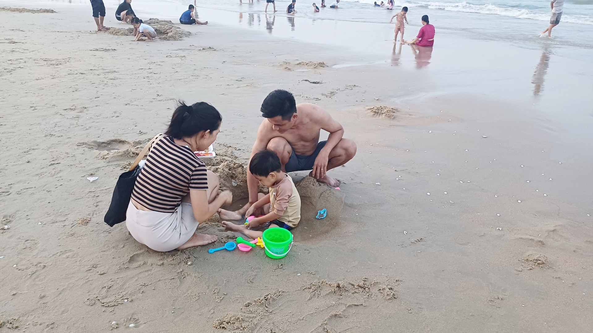 Phần lớn các gia đình dẫn con đi tắm biển và vui chơi sau những giờ làm việc, học tập. Ảnh: Q.H