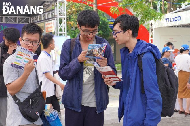 Sinh viên quan tâm đến nhu cầu tuyển dụng của một số doanh nghiệp. Ảnh: NGỌC HÀ