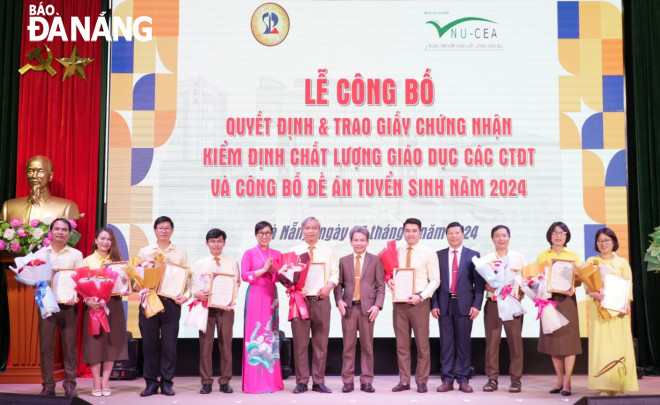 Đại diện Trung tâm Kiểm định chất lượng giáo dục, ĐHQG HN trao giấy chứng nhận cho các khoa có CTĐT đạt chuẩn. Ảnh: NGỌC HÀ