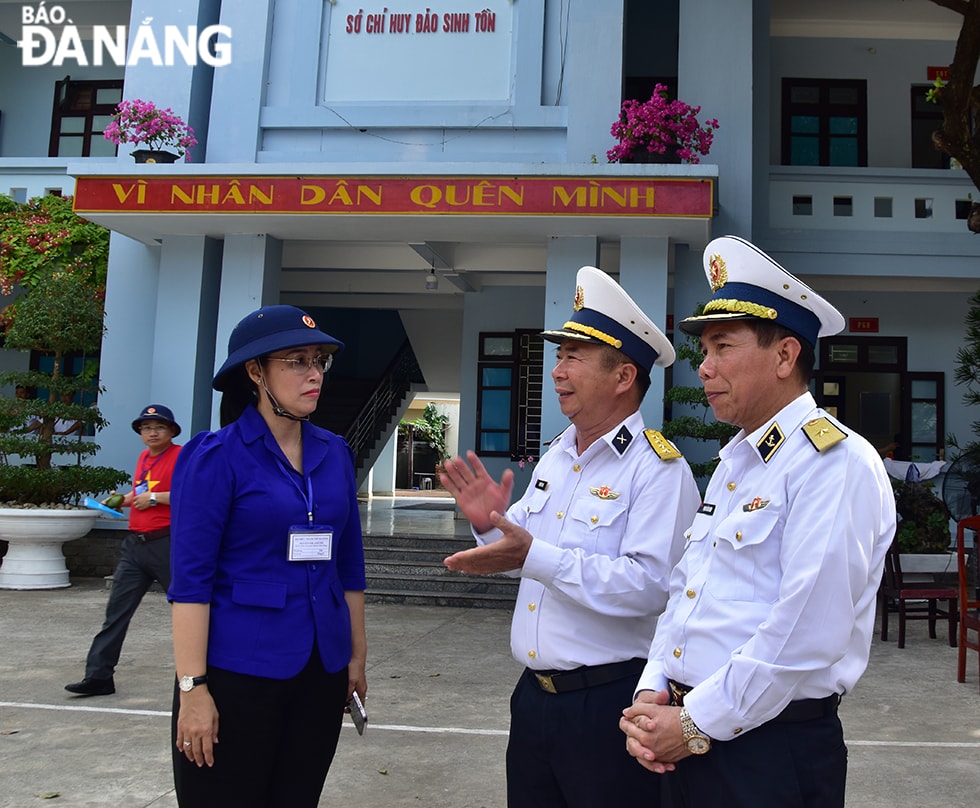 Chuẩn đô đốc, Phó Tổng Tham mưu trưởng Quân chủng Hải quân Việt Nam Phạm Văn Hùng (bên phải) và Phó Chủ tịch HĐND thành phố Đà Nẵng Nguyễn Thị Anh Thi nghe báo cáo tình hình công tác, đời sống của quân và dân trên đảo Sinh Tồn. Ảnh: TRIỆU TÙNG