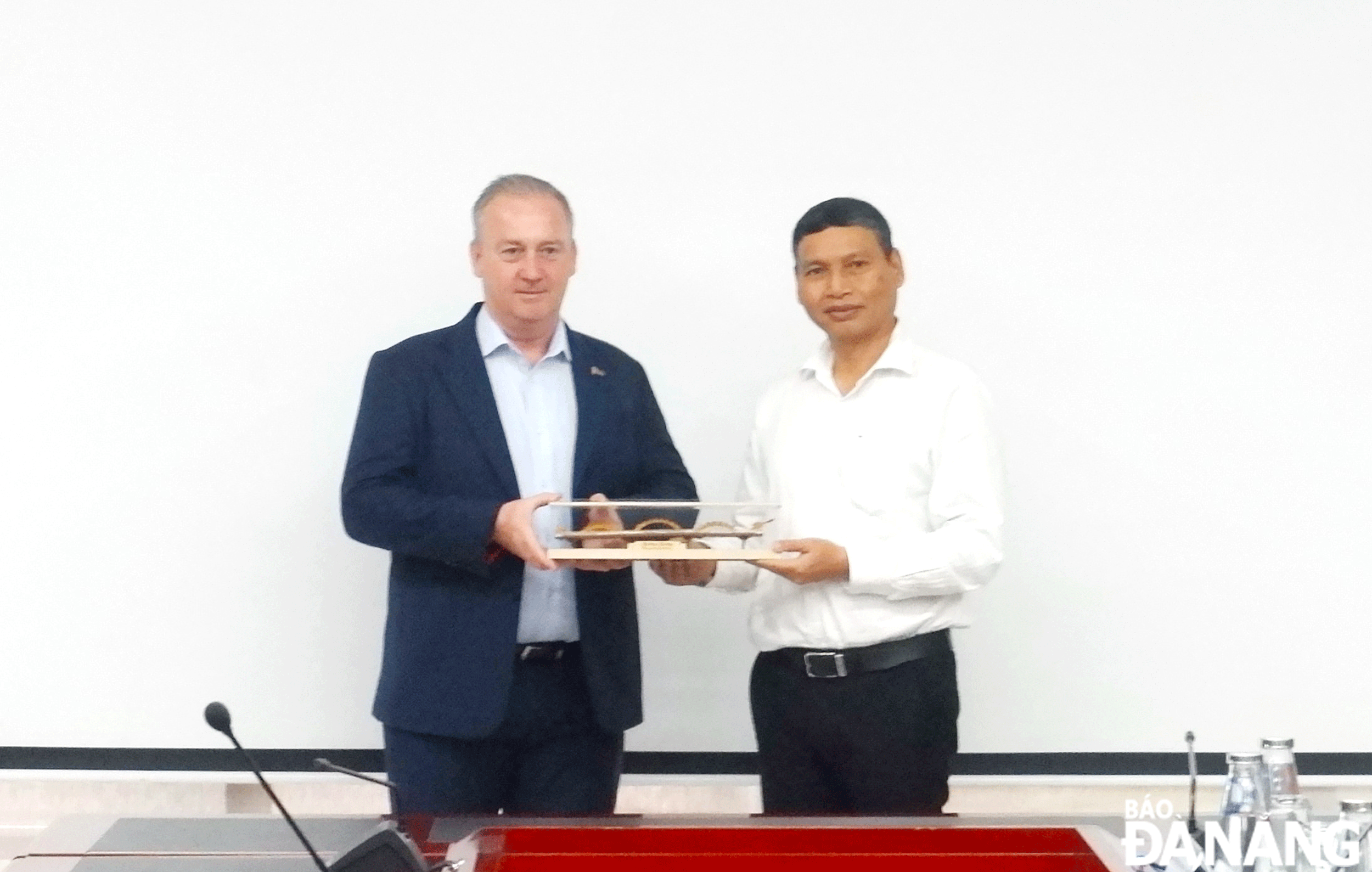 Phó Chủ tịch Thường trực UBND thành phố Hồ Kỳ Minh (bên phải) trao quà lưu niệm cho ông Jeffrey Goss, Phó Hiệu trưởng Trường Đại học Bang Arizona (Hoa Kỳ). Ảnh: M.Q