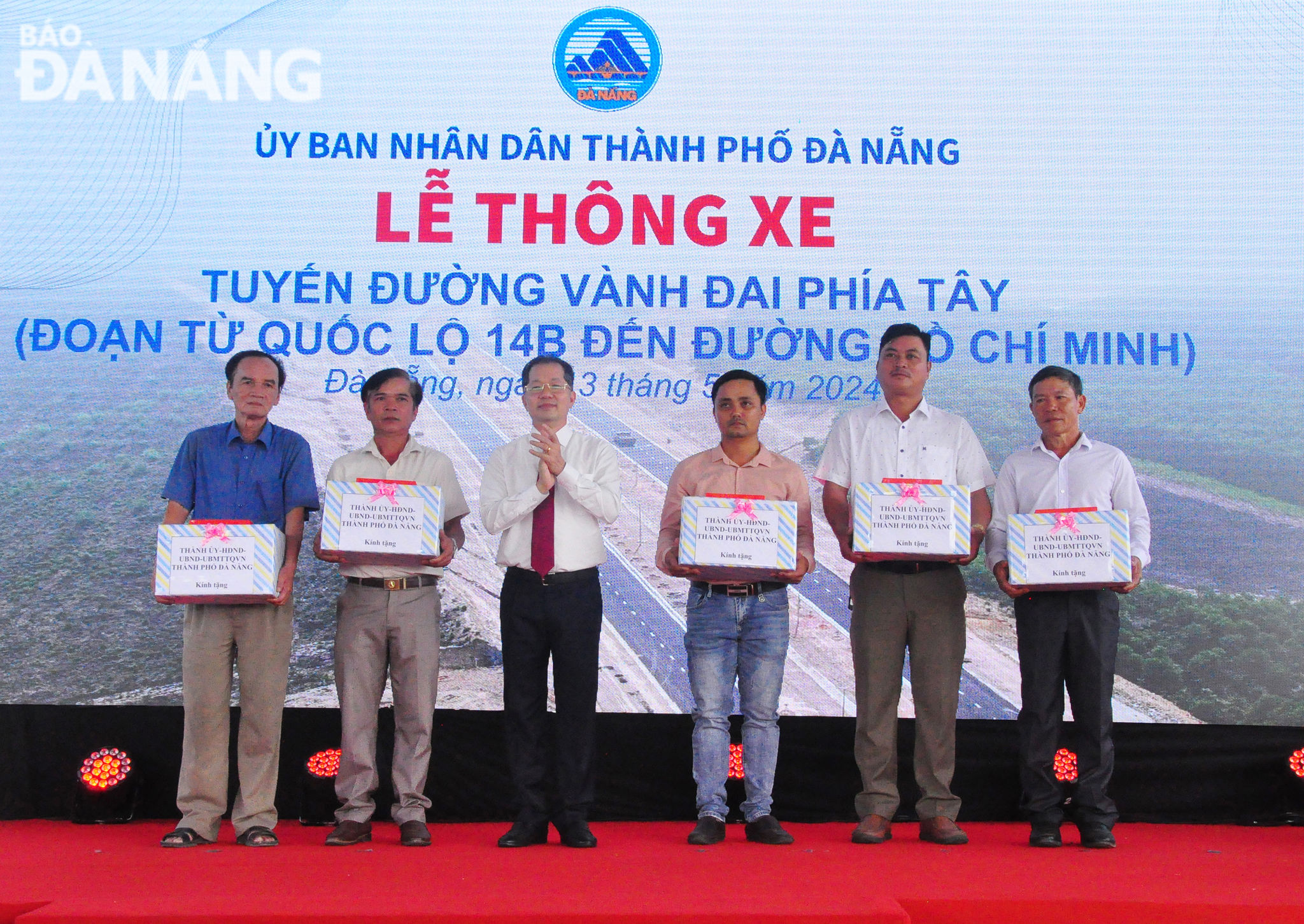 Bí thư Thành ủy Nguyễn Văn Quảng (thứ 3 từ tái sang) tặng quà cho các hộ dân trên tuyến đường đi qua. Ảnh: THÀNH LÂN