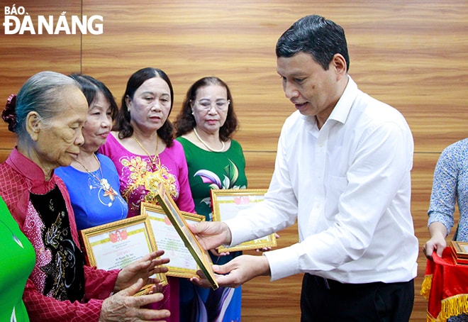 Phó Chủ tịch Thường trực UBND thành phố Hồ Kỳ Minh tặng giấy khen cho các phụ nữ tiêu biểu. Ảnh: X.D
