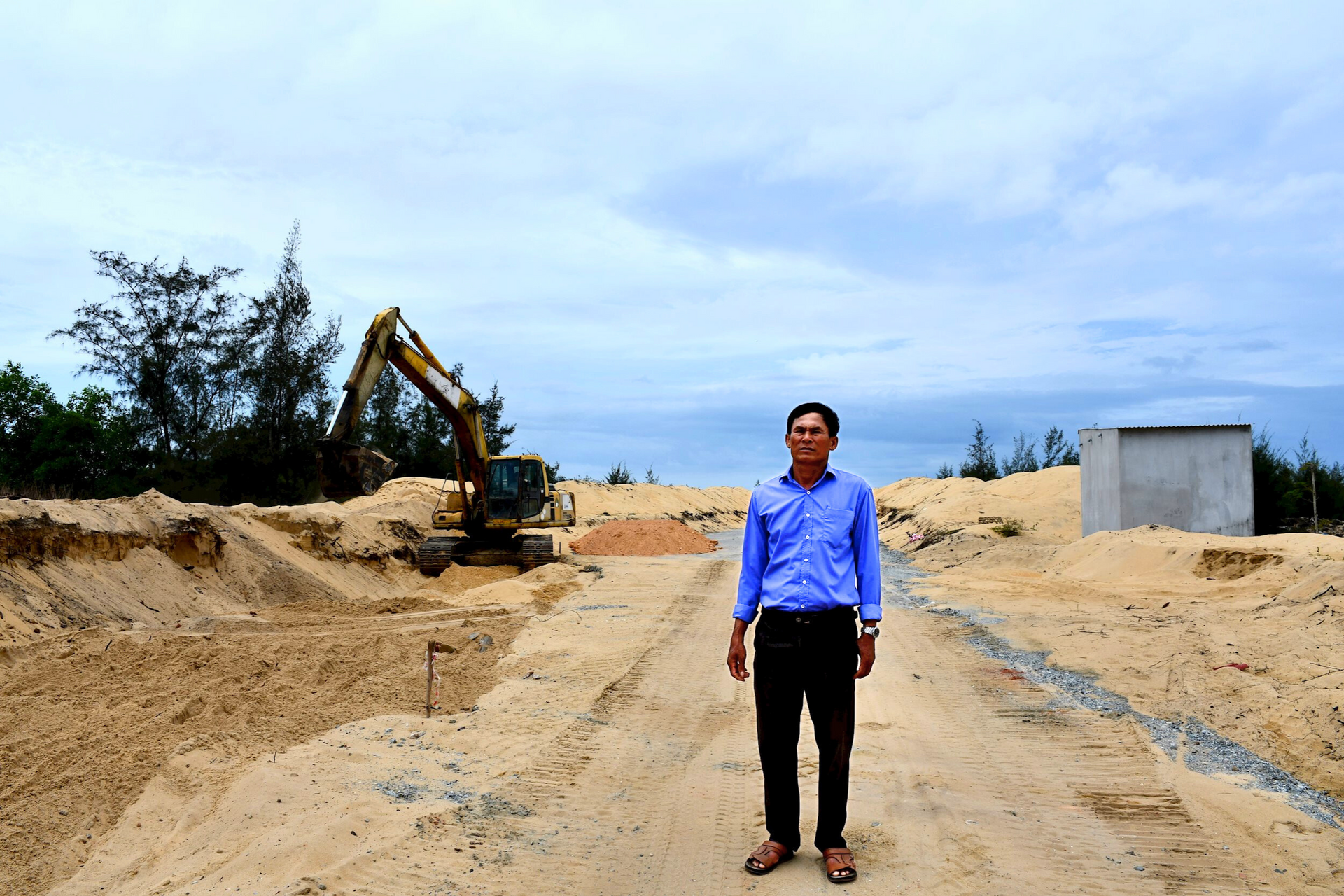 Ông Trần Văn Nam bên dự án cầu Tây Giang đang được thi công. Ảnh: Q.VIỆT