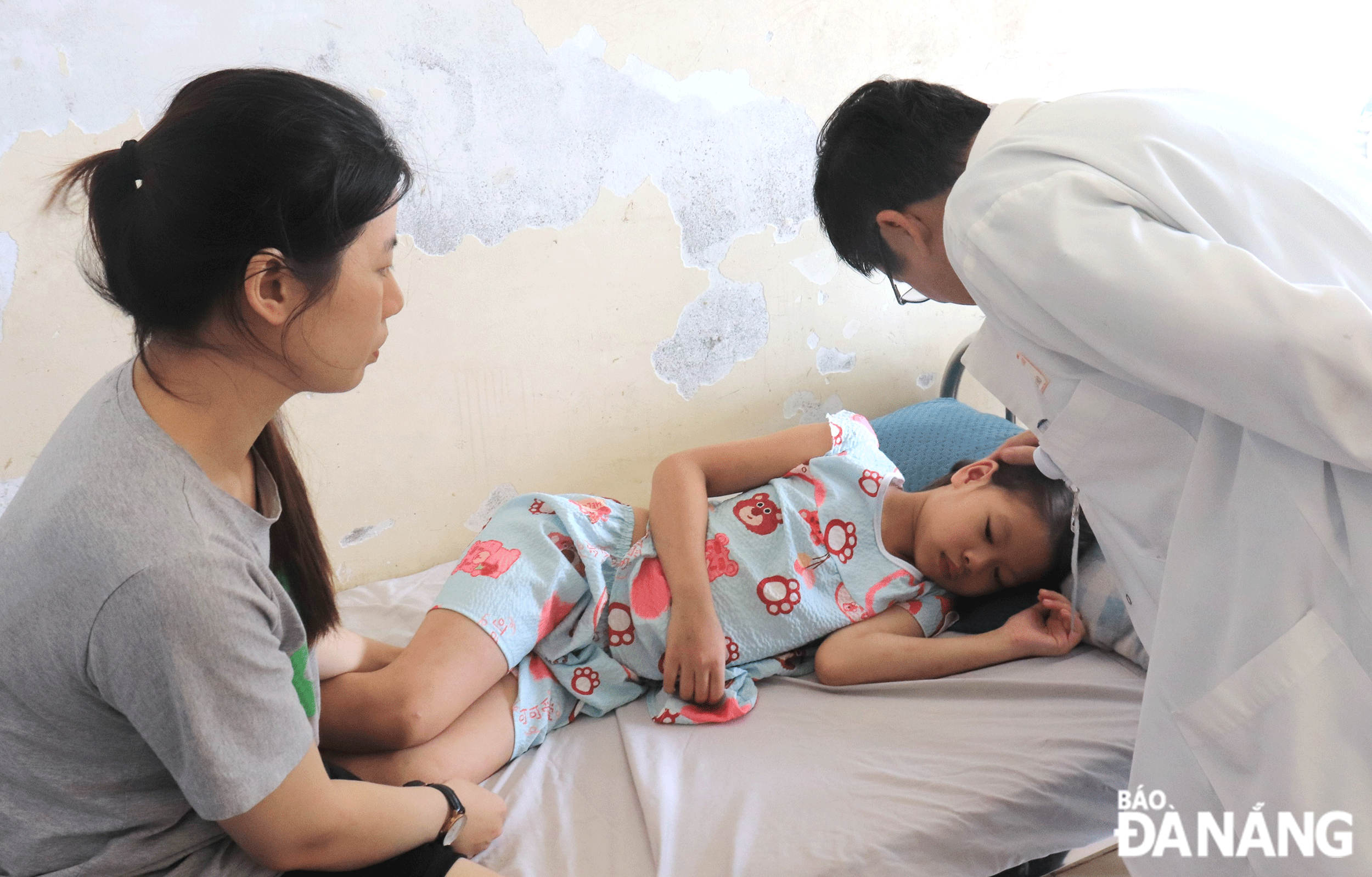 Bác sĩ Đặng Văn Hào, Trưởng Khoa Nhi tổng hợp, Bệnh viện Phụ sản - Nhi Đà Nẵng đang thăm khám cho bệnh nhi Lâm Thảo Ngọc. Ảnh: ĐẮC MẠNH