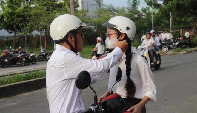 Phụ huynh đưa con đến điểm thi. Ảnh: NGỌC HÀ