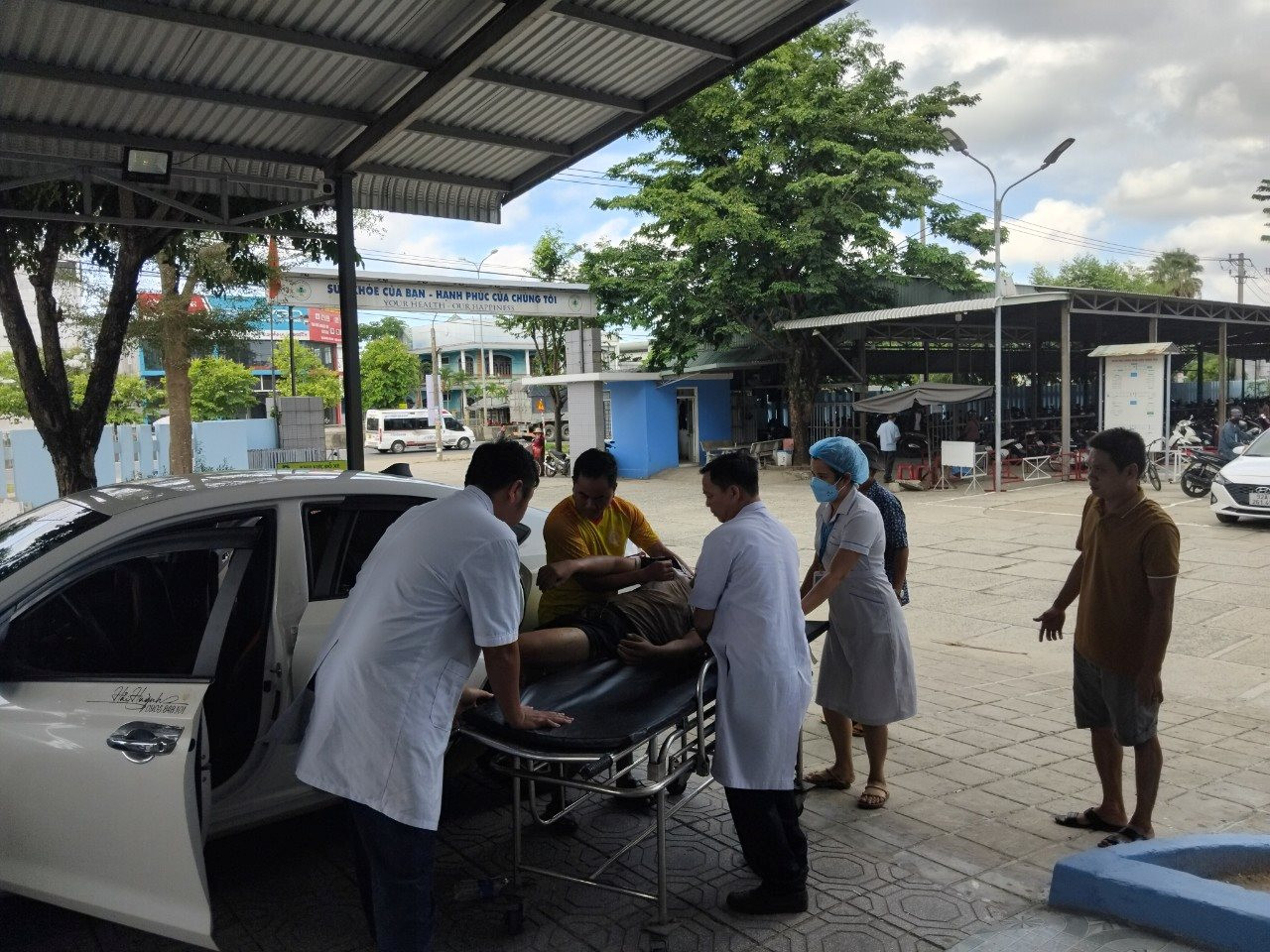 Anh Huỳnh Văn Hải (áo vàng) chở cấp cứu miễn phí 2 thanh niên đến bệnh viện kịp thời vào chiều 25/6 vừa qua. Ảnh: BIÊN THỰC
